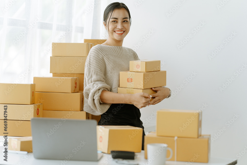 ortrait of a small business startup, SME owner, female entrepreneur, working, unboxing, checking orders online. To prepare to pack boxes for sale to SME customers online business ideas ortrait of a small business startup, SME owner, female entrepreneur, working, unboxing, checking orders online. To prepare to pack boxes for sale to SME customers online business ideas