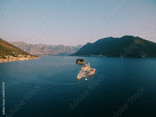 Boat sails along the Bay of Kotor to the island of Gospa od Skrpjela. Montenegro