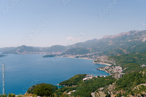 Bay of Kotor surrounded by green mountains in a light haze against the blue sky. Montenegro