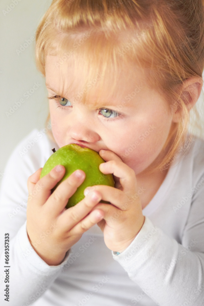 Baby, hungry girl and eating apple with thinking, learning and nutrition for growth in childhood at family home. Infant child, toddler and biting green fruit for health, wellness and diet in house Baby, hungry girl and eating apple with thinking, learning and nutrition for growth in childhood at family home. Infant child, toddler and biting green fruit for health, wellness and diet in house