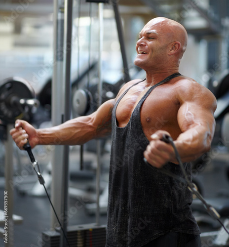 Bodybuilder man, exercise equipment and crossover with cable, strong and workout with smile for progress. Guy, training and fitness with muscle, health or wellness with weightlifting for competition © Julie Francoeur/peopleimages.com