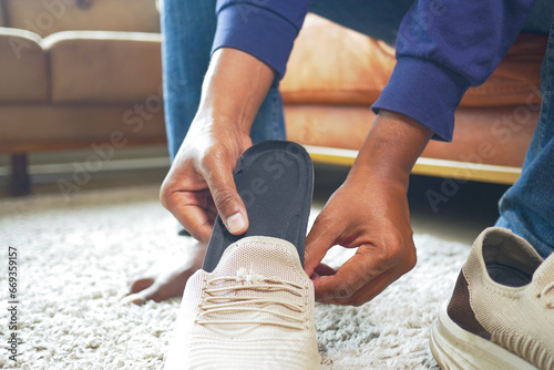 men hand putting Orthopedic insoles in shoes  photo