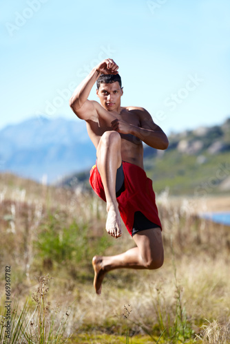 Portrait, kickboxing and man with training, field and workout with exercise, wellness and nature. Person, athlete or guy with practice, countryside or grass with health, karate or jump with challenge