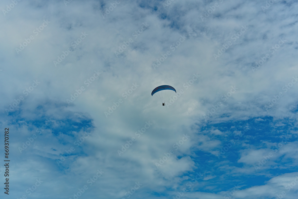 Floating paraglider in the sky with clouds in the mountains Floating paraglider in the sky with clouds in the mountains