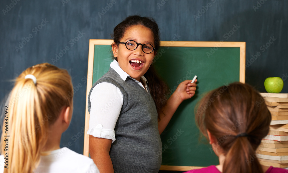 Excited, board and portrait of child student in a classroom teaching a lesson to friends. Happy, smile and girl kid writing with chalk for education studying, learn or knowledge at school or academy. Excited, board and portrait of child student in a classroom teaching a lesson to friends. Happy, smile and girl kid writing with chalk for education studying, learn or knowledge at school or academy.