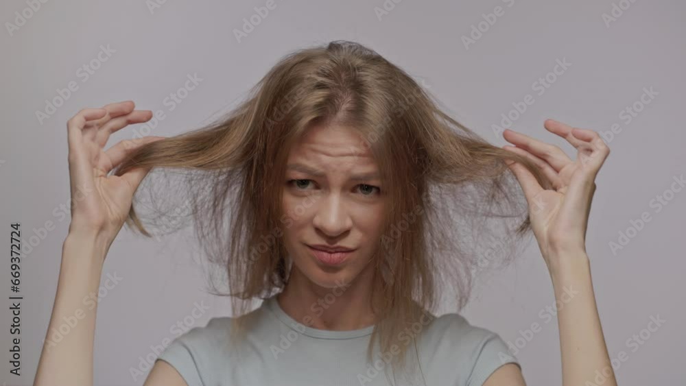 A woman shows her thin bad hair. Thinning and hair loss. Emotional disorders