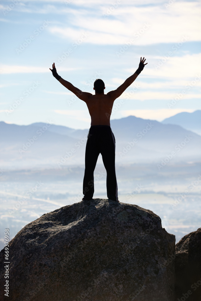 Mountain top, success and back of fitness man stretching arms in nature for performance celebration on sky background. Exercise, freedom and rear view of male athlete with workout, energy or victory