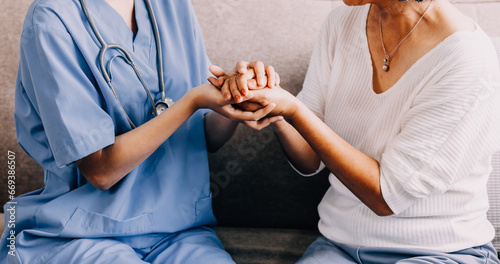 Happy senior woman visiting doctor, getting optimistic news after medical checkup, therapy. Therapist holding hand of old patient, giving hope, support, congratulating on goor treatment result