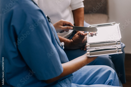 Doctor and patient sitting and talking at medical examination at hospital office, close-up. Therapist filling up medication history records. Medicine and healthcare concept.