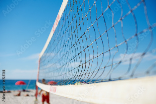 Volleyball, net and beach with blue sky outdoor for game, competition or match. Ocean, sports netting closeup or sand field for training, exercise and workout, fitness or sea for recreation in summer