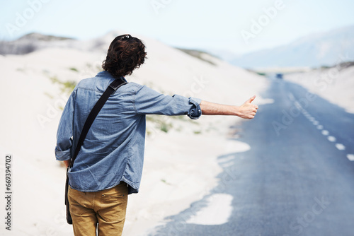 Foto Back, man or hitchhiker in nature on road for travel, destination or road trip with thumbs up in street