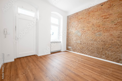 empty office or apartment room with brickwall and wooden floor
