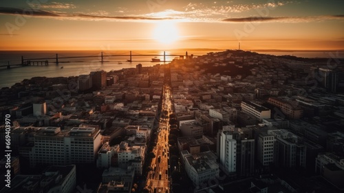 A breathtaking aerial view captures a city at sunset, with its sprawling urban landscape bisected by a long avenue, leading to a distant bridge and shimmering waters. Perfect for urban development