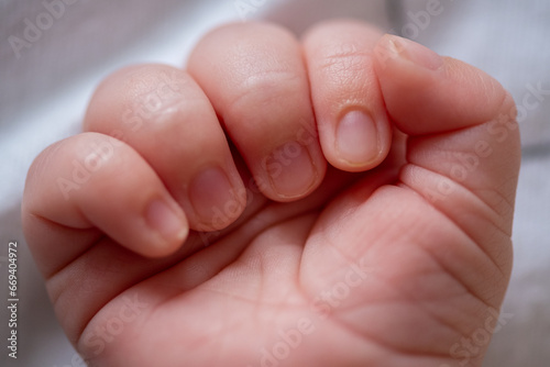 Macro shot of an infant's healthy hand while he is sleeping. Beautiful picture of a caucasian baby palm. Family and parenthood concept.