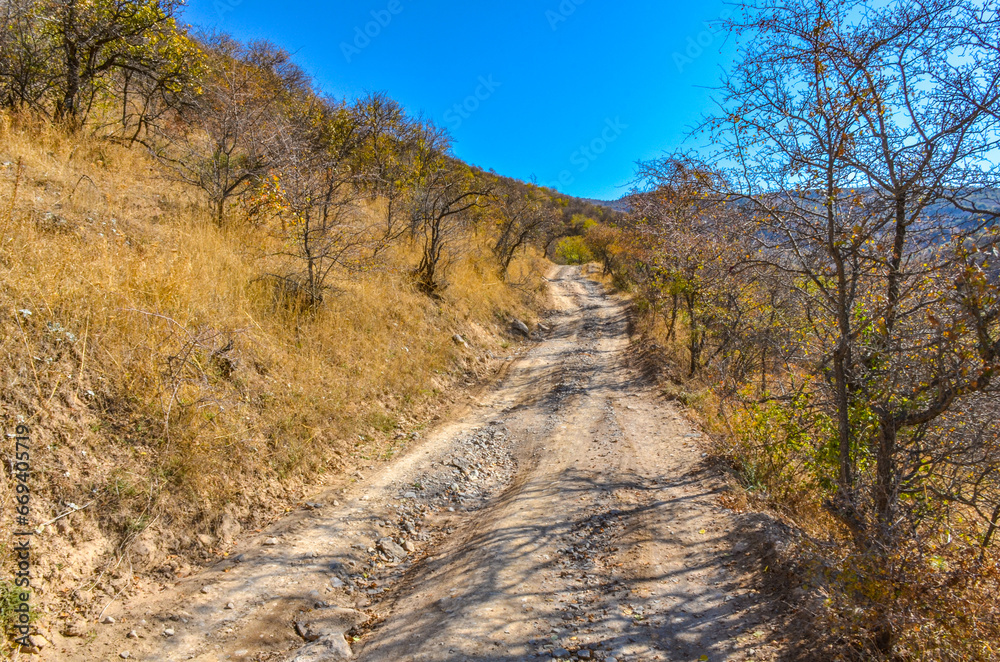 dirt road in the mountains of Kungurbuka ridge near Karankul village (Tashkent region, Uzbekistan) dirt road in the mountains of Kungurbuka ridge near Karankul village (Tashkent region, Uzbekistan)