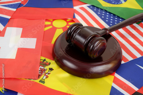 Wooden gavel on countries flags background. International laws and political decisions concept. photo