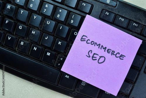 Concept of Ecommerce SEO write on sticky notes isolated on Wooden Table.