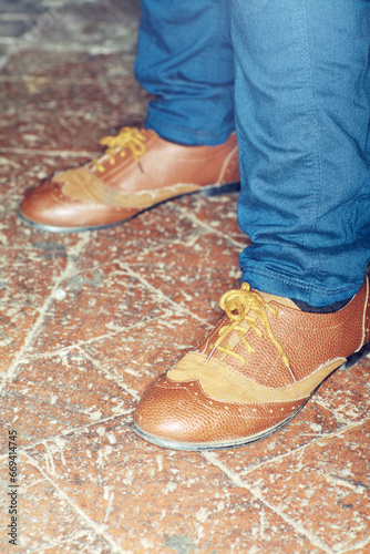 Footwear, style and closeup of man feet by brick floor for elegant, stylish and trendy outfit. Fashion, shoes and zoom of male person with luxury, classy and expensive fashion with jeans by pavement.