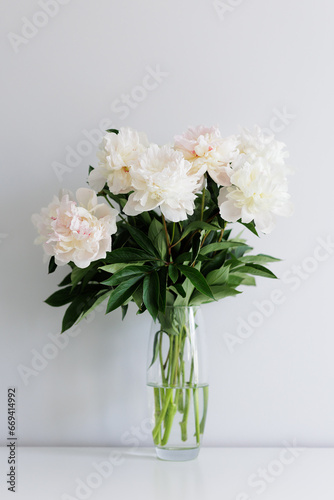 Close up of beautiful fresh white peonies bouquet in vase