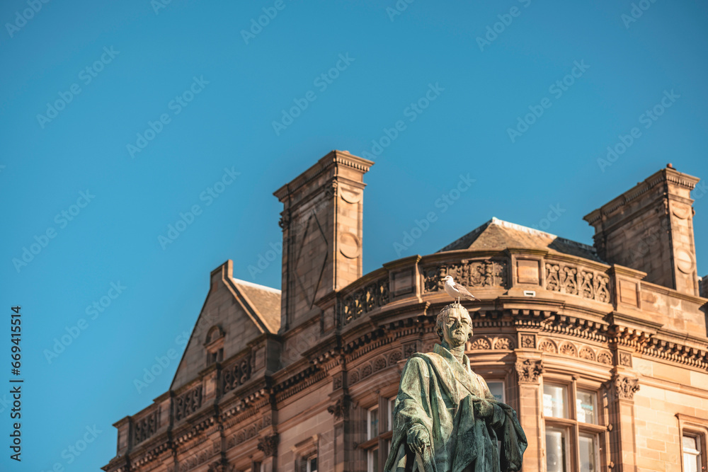 Edinburgh a sculpture of a male figure standing in front of an architectural structure