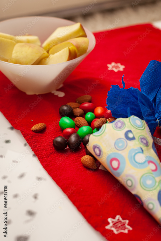 Sweet glazed candies are scattered on the table. Chopped apples in a bowl. Holiday concept Sweet glazed candies are scattered on the table. Chopped apples in a bowl. Holiday concept
