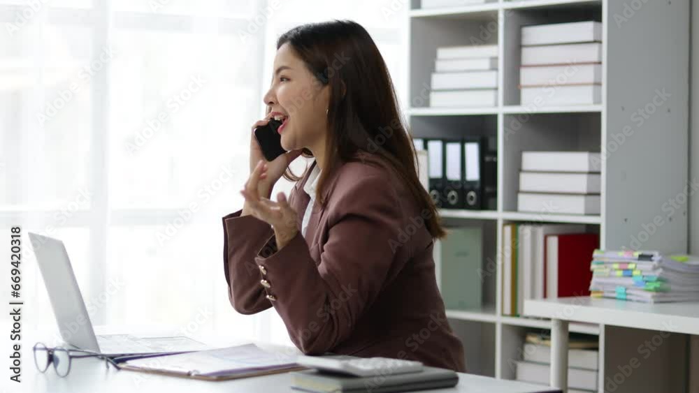 Asian businesswoman secretary in office talking on phone with boss. Asian businesswoman secretary in office talking on phone with boss.