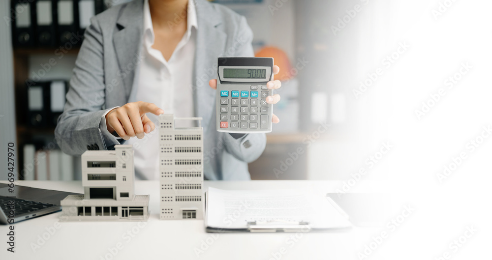 Real estate broker agent presenting and consult to customer to decision making sign insurance form agreement, home model, concerning mortgage loan offer .. Real estate broker agent presenting and consult to customer to decision making sign insurance form agreement, home model, concerning mortgage loan offer ..