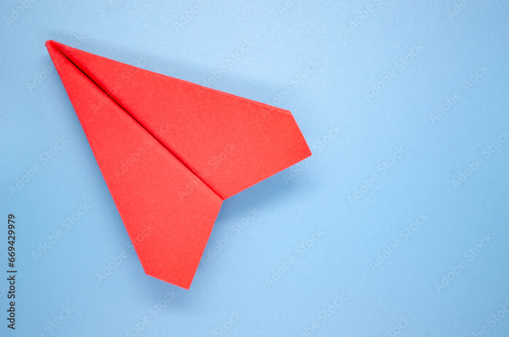 Top view of red paper airplane on blue background with customizable space for text. Copy space and plane concept Top view of red paper airplane on blue background with customizable space for text. Copy space and plane concept
