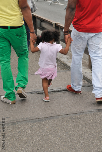 Geneva, Switzerland, Europe - two men with little girl walking the street