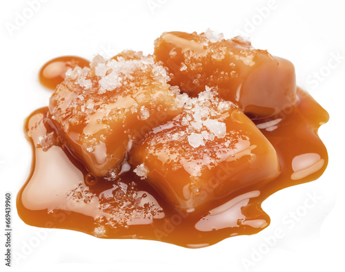 Caramel candies covered with melt caramel and salt crystals isolated on white background.