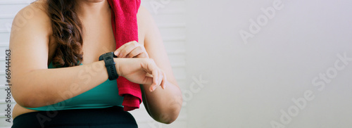 Large size fit woman looking at smart watch, banner.