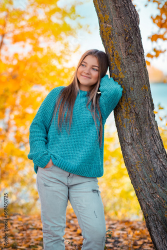 Wallpaper Mural A teenage girl walks by herself in an autumn park near the river. She is joyful and happy. Torontodigital.ca