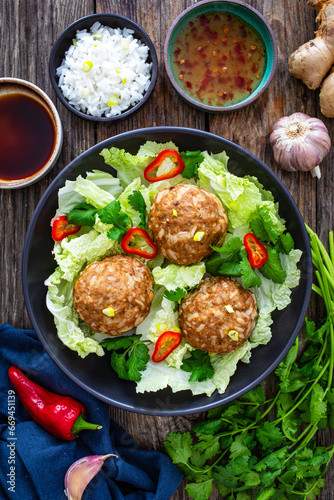 Lion's head meatballs - steamed big meatballs served with vegetables on wooden background 
