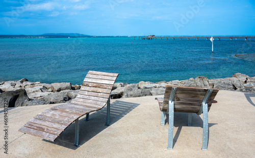 Two wooden empty deckchairs for sunbathing on the pier of Lake Constance - Bodensee - in swiss Altnau © Taljat