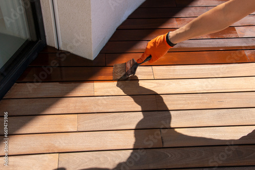 Deck sealing, worker hand applying a wood stain