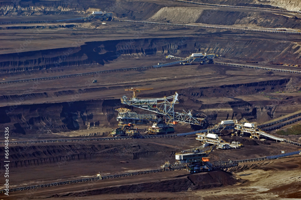 Wnętrze wyrobiska kopalni odkrywkowej węgla brunatnego w Bełchatowie, z kilkoma pracującymi maszynami - kombajnami górniczymi. Polska. 