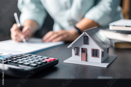 Mortgage property insurance dream moving home and real estate concept.Female calculate finance expenditures on machine, manage plan family household budget, insurance or loan real estate or property. photo
