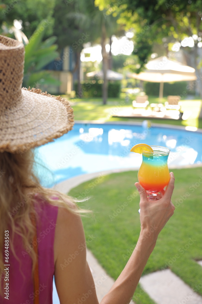  Cocktail in the hands of a woman, A woman holding a cocktail by the pool, alcoholic juice by the pool, juice by the pool