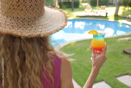  Cocktail in the hands of a woman, A woman holding a cocktail by the pool, alcoholic juice by the pool, juice by the pool
