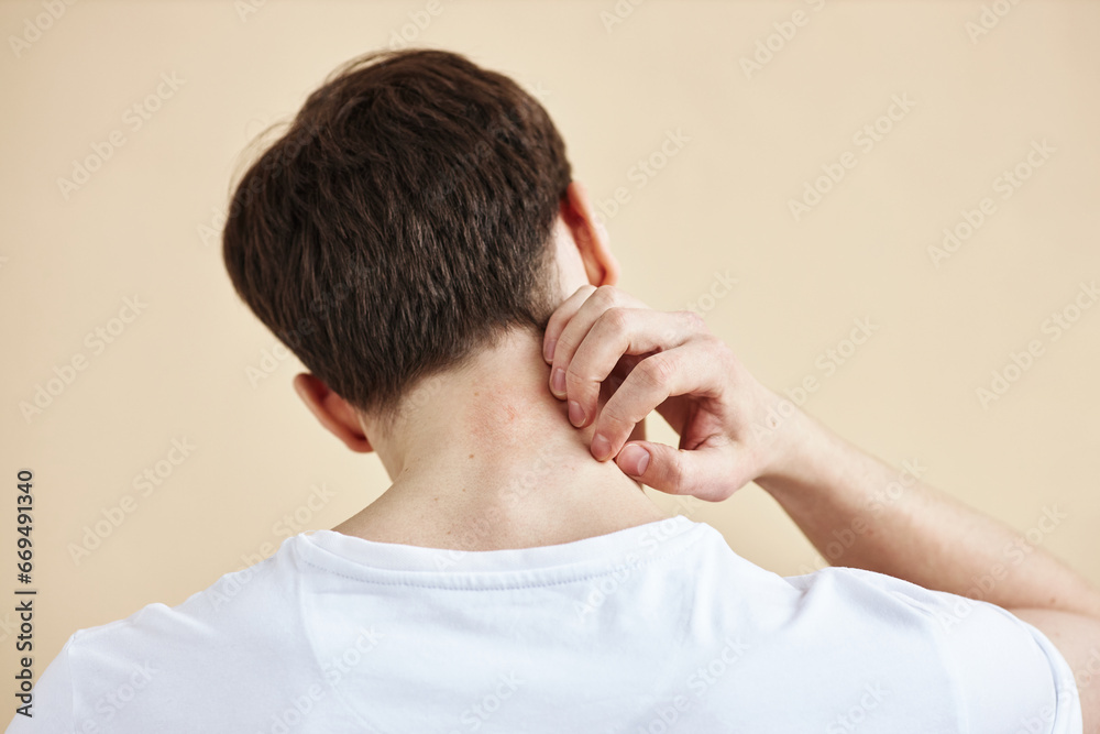 Back view of man scratching neck suffering from rash or skin condition, copy space Back view of man scratching neck suffering from rash or skin condition, copy space