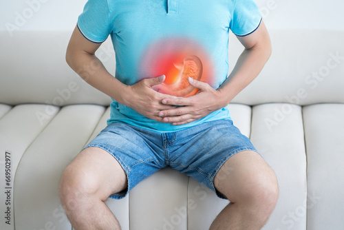 Stomach ulcer, man with abdominal pain suffering at home, symptoms of gastritis, diseases of the digestive system photo