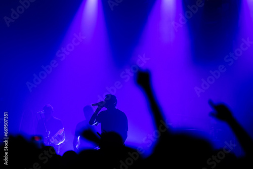 Audience beneath blue lights - rock concert