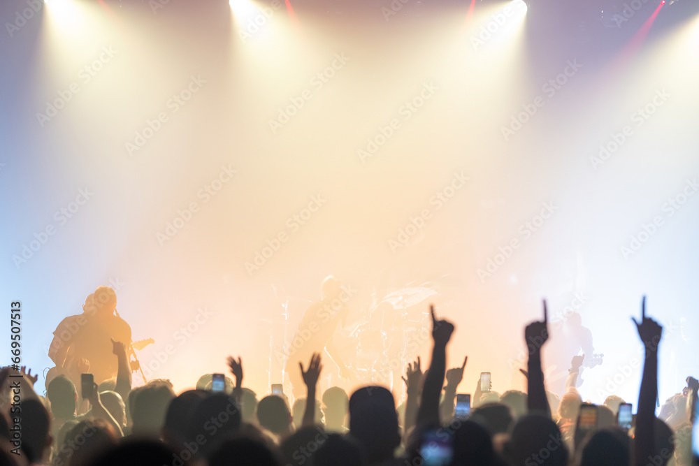 Crowd raising hands under bright light - rock concert Crowd raising hands under bright light - rock concert