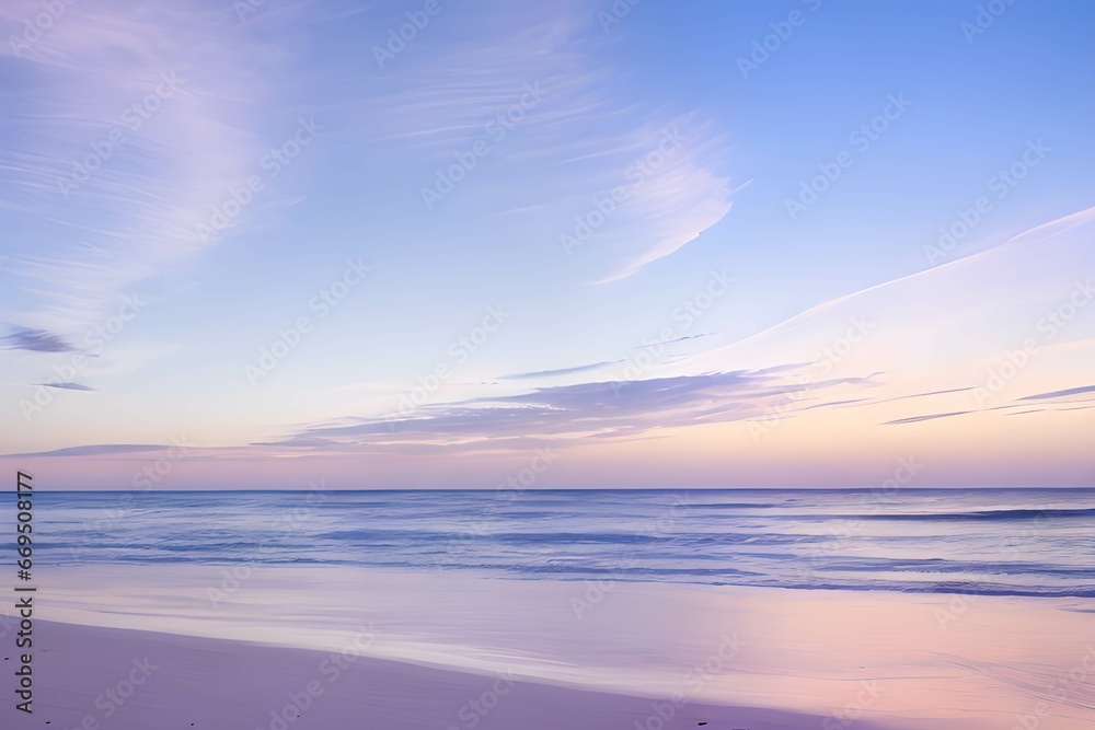 うっすらとした雲と穏やかな波が打ち寄せるパステルカラーのビーチの日の出