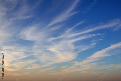 青とオレンジのコントラストが魅力的な空、ふわふわとした雲が描く穏やかな風景