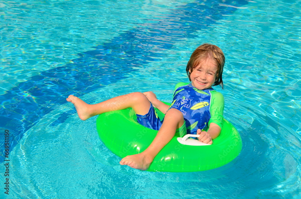 The child enjoys summer. Traveling with children. family resort. Boy swimming in the pool
