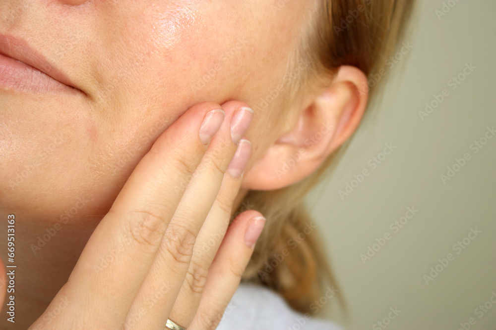 Close up of woman using moisturising skin serum on her face