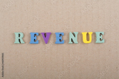 REVENUE word on wooden background composed from colorful abc alphabet block wooden letters, copy space for ad text. Learning english concept. photo