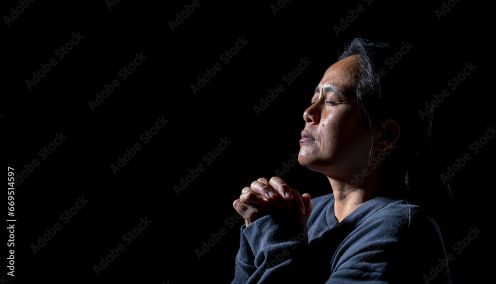 Woman person are praying in dark background. Female christian worship to god in faith. banner, panorama with copy space. Girl christian meditation and pray in christ. Christianity religion concept. - obrazy, fototapety, plakaty 