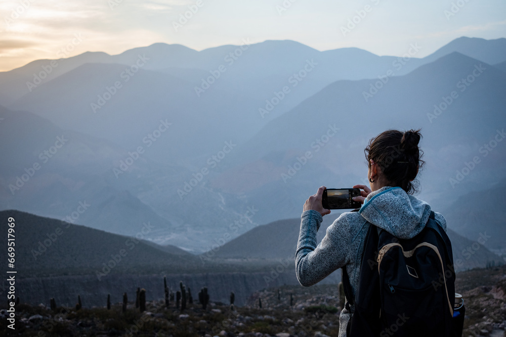 Mujer turista tomando una foto en los cerros de Tilcara, Jujuy, Argentina - obrazy, fototapety, plakaty 